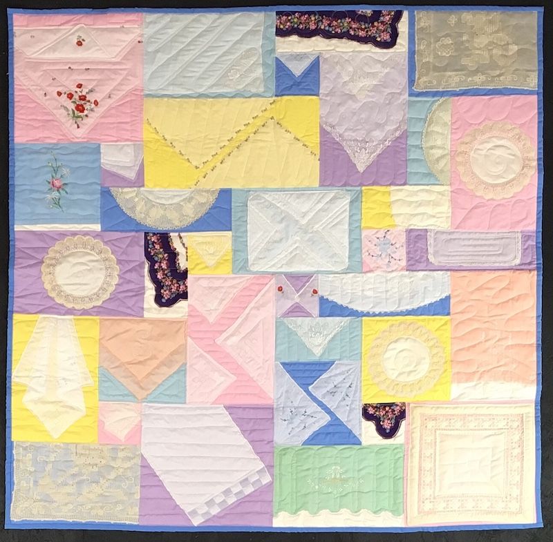 Hankies made into a quilt on a pastel background