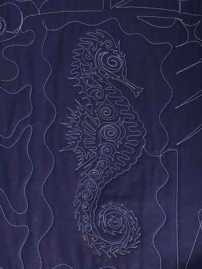 The back of a T-shirt quilt with a sea horse that has been traced.